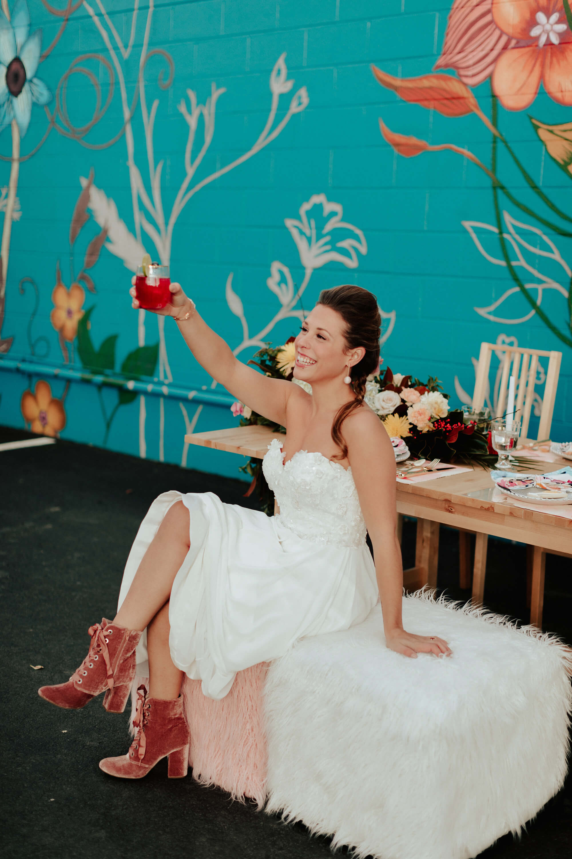 bride toasting with pink cocktail in pink boots