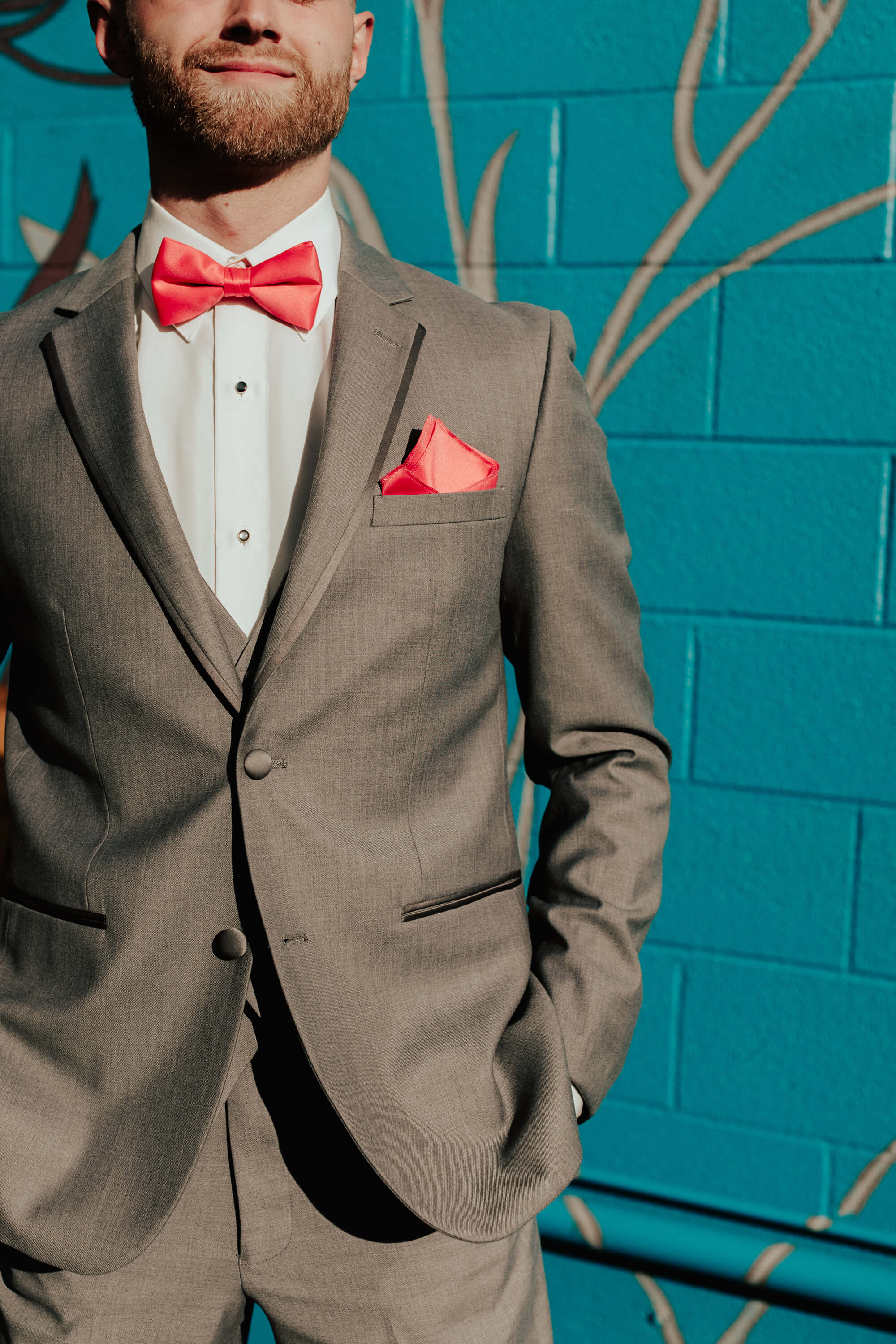 groom grey suit with coral bowtie and pocket square