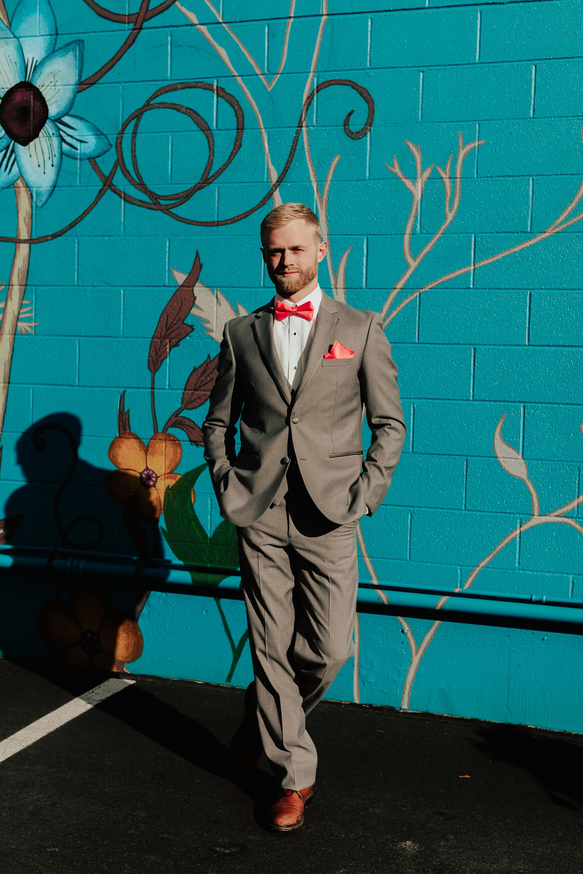 groom in grey suit with coral accents