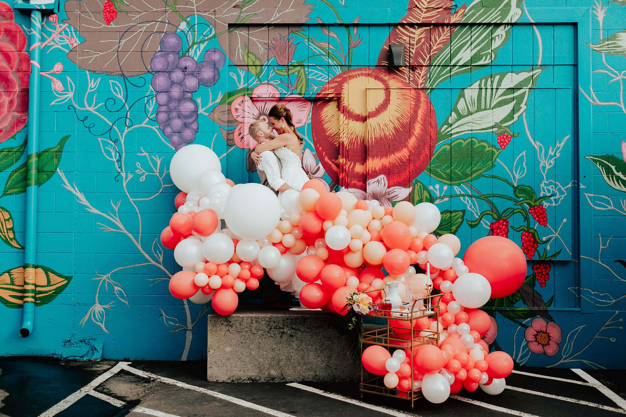 wedding with balloons and bright colorful mural