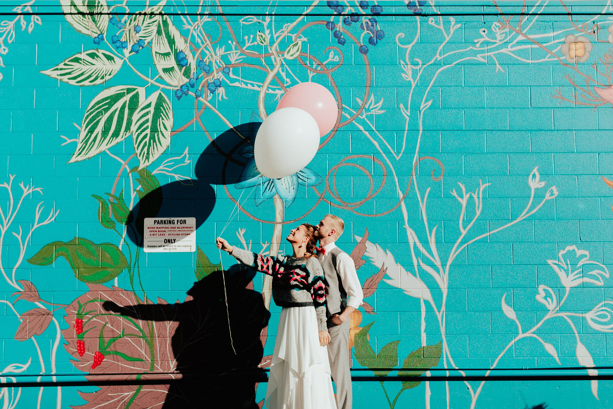 bride and groom holding balloons