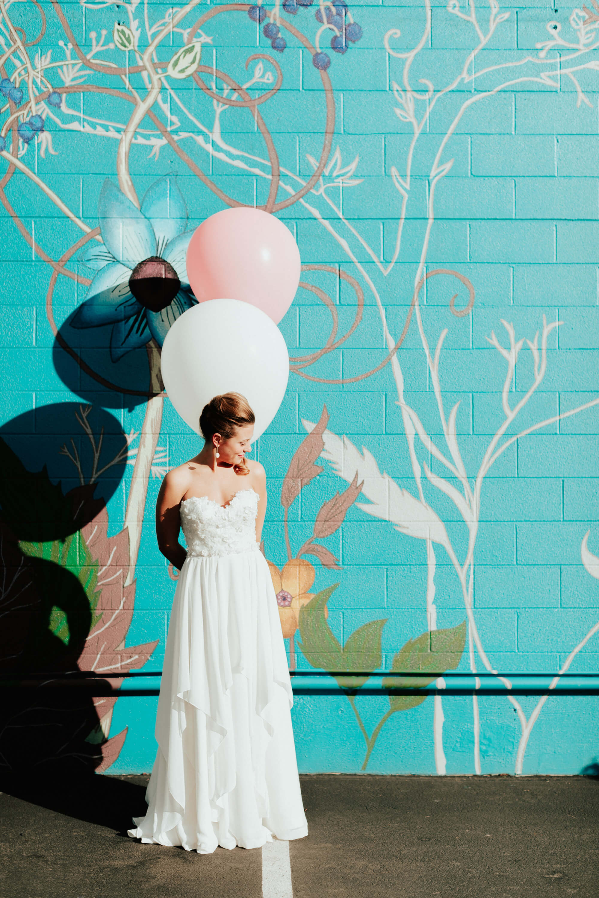 bride holding pink and white balloons