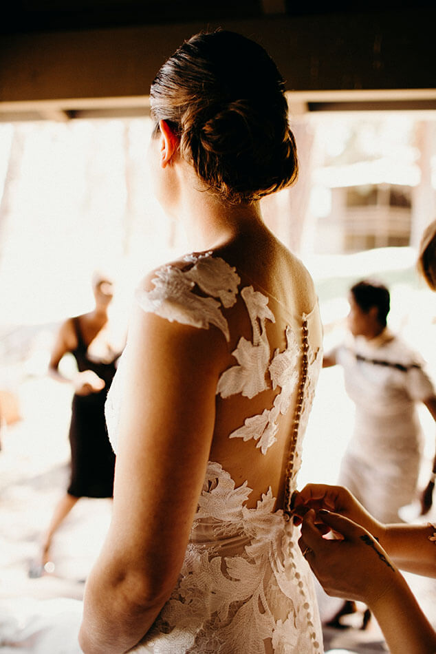 bride buttoning modern floral wedding dress