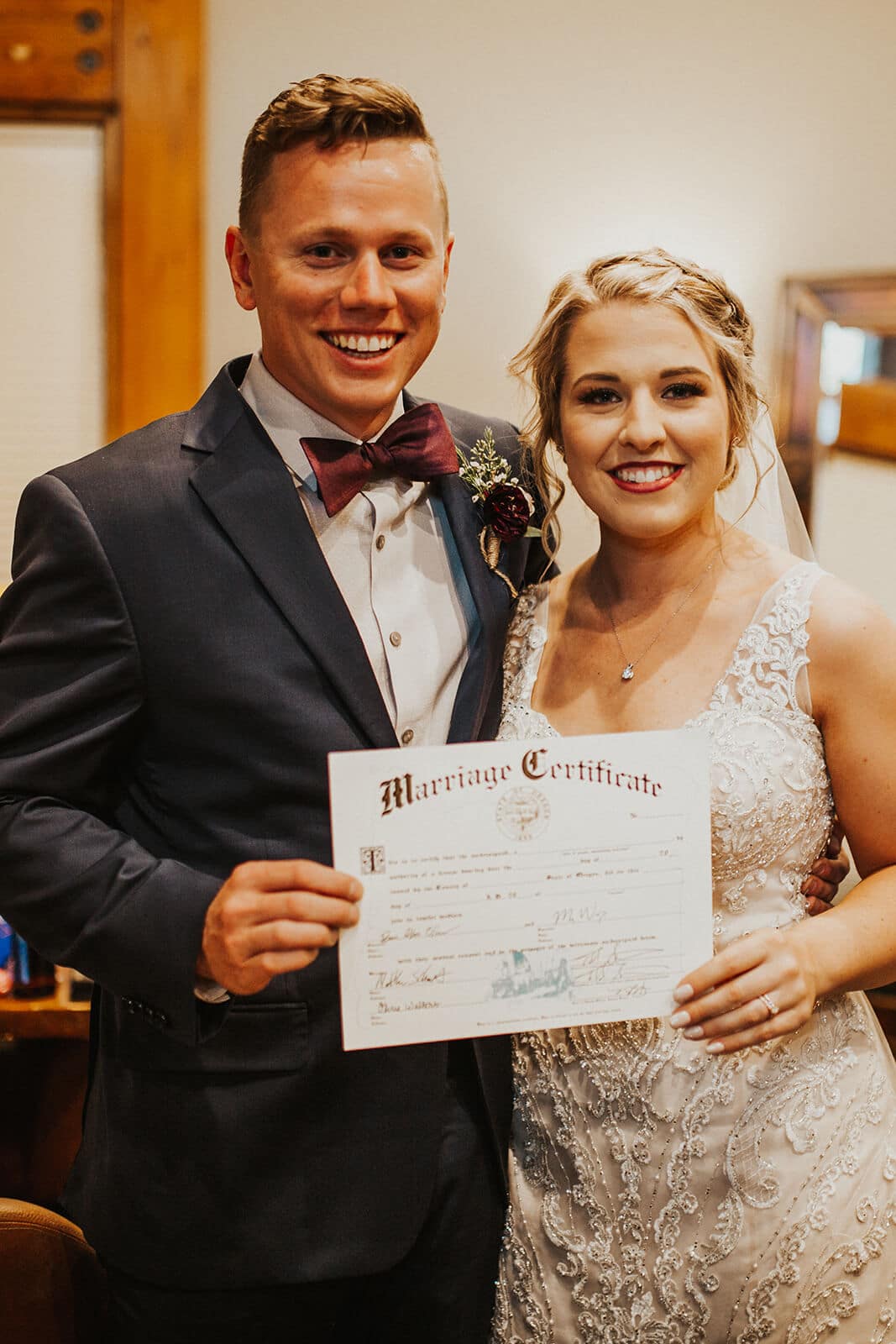 bride and groom with marriage certificate