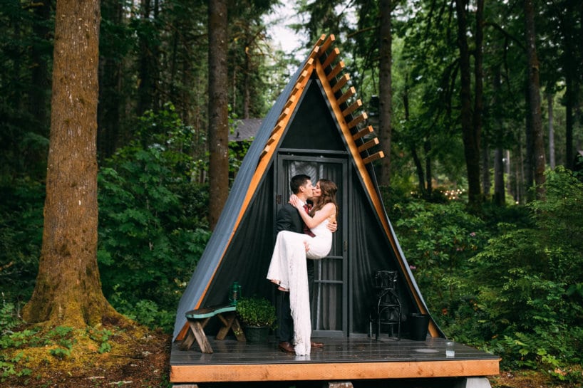 bride and groom kissing near tent