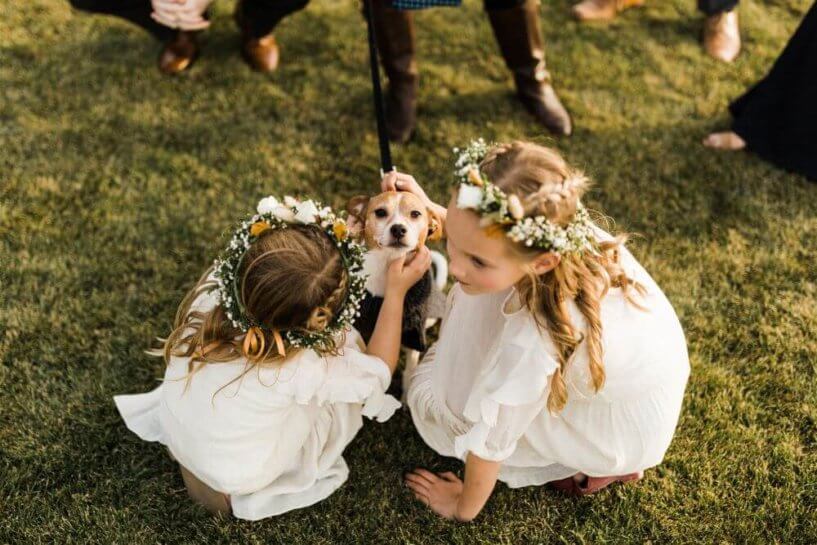 flower girls petting a small dog