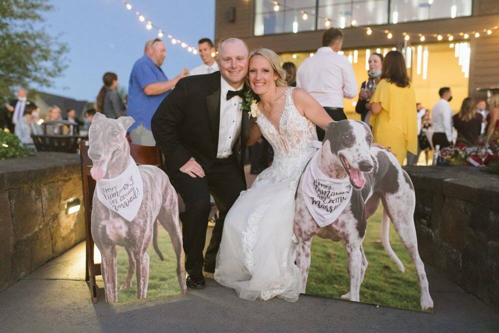 wedding couple with cardboard cutouts of their dogs