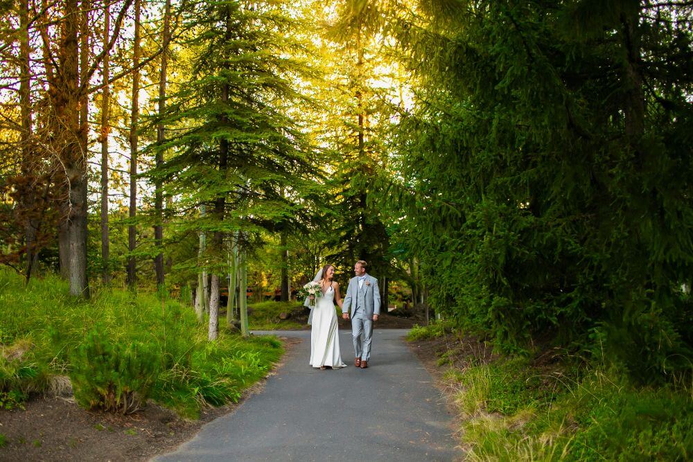 bride and groom walking through forest
