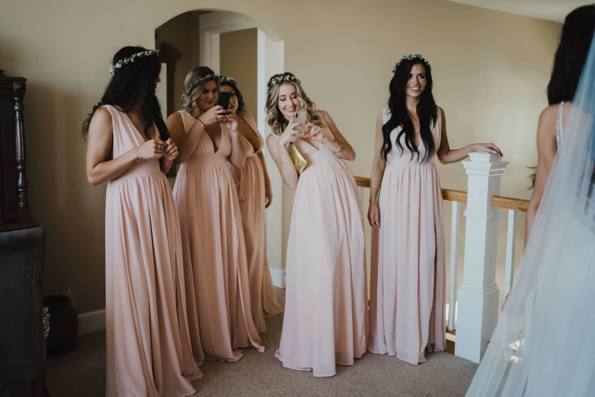 bridesmaid in pink dresses taking photos with their cell phones