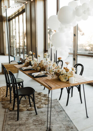 wooden table with black chairs and flowers