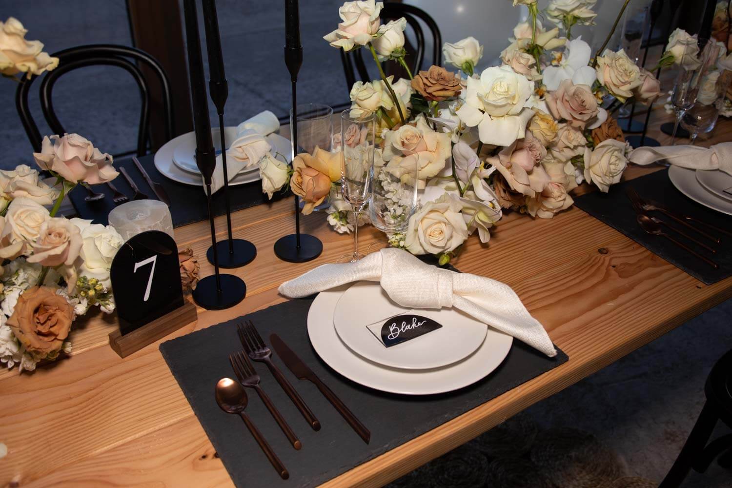 white napkins and black charger on table