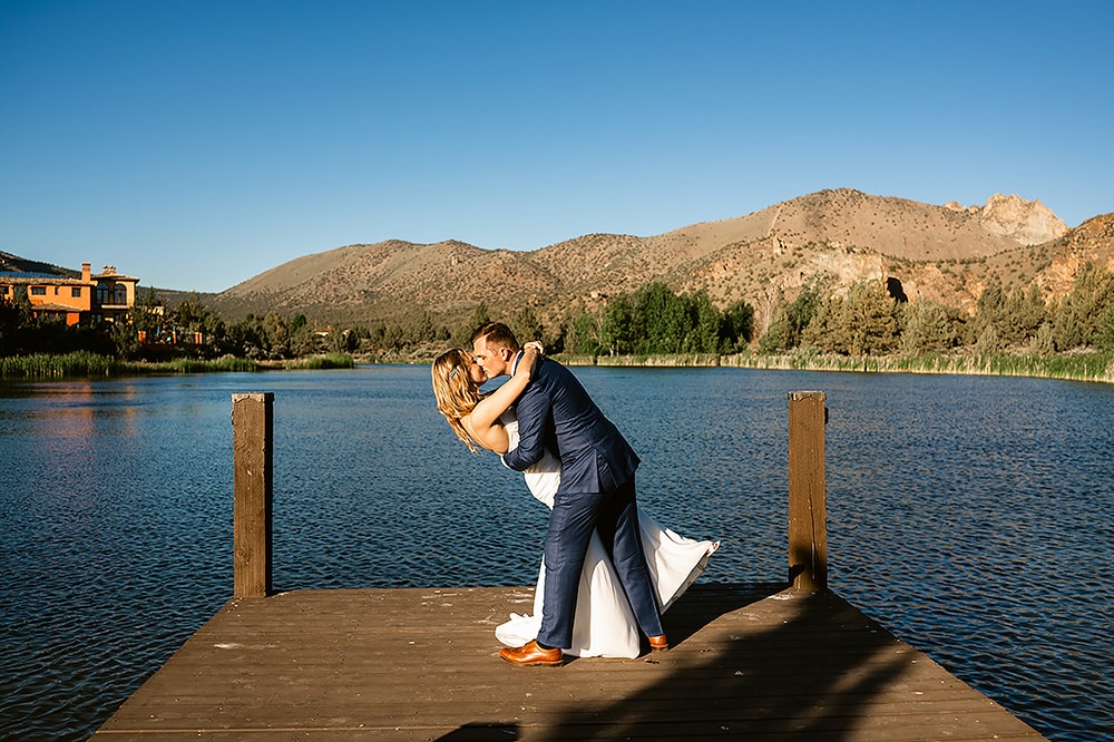 bride and groom on dock kissing