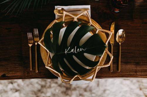 gold wedding plates tropical leaf name card